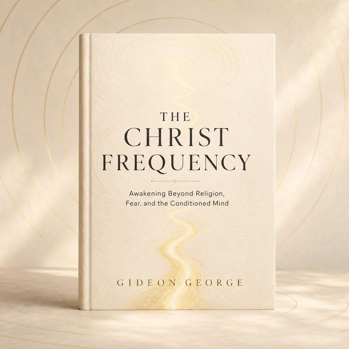 The hardback edition of The Christ Frequency: Awakening Beyond Religion, Fear, and the Conditioned Mind by Gideon George, an ivory cover with a gold thread of light running through it